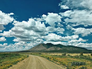 Scenic view of field against cloudy sky