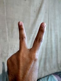 Close-up of human hand against wall