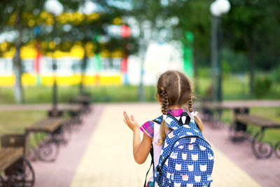 Rear view of woman with umbrella standing against blurred background