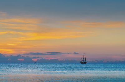 Sailboat in sea against sky during sunset