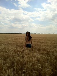 Scenic view of grassy field against sky