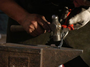 Cropped hands of manual worker working in workshop