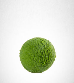 Close-up of green ice cream scoop against white background