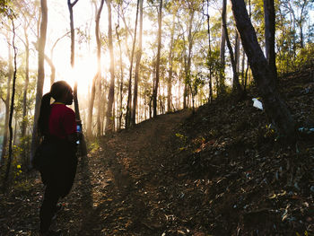 Rear view of woman walking in forest