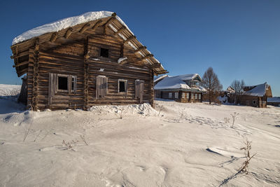 Exterior of abandoned building against clear sky during winter