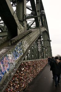 Rear view of people walking on bridge
