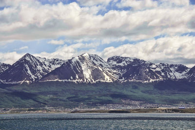 Scenic view of snow covered mountains against cloudy sky