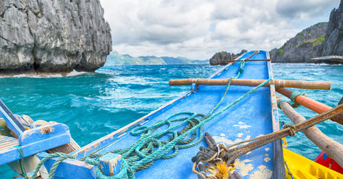 Boat moored on sea shore against sky