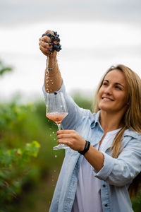 Portrait of a smiling young woman drinking water
