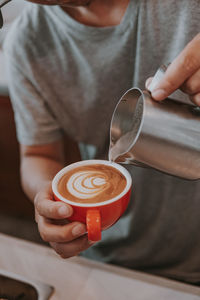 Midsection of man holding coffee cup