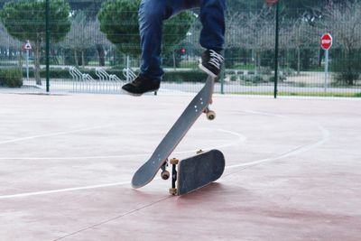 Low section of man doing stunt with skateboard