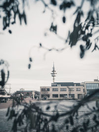 Buildings in city against cloudy sky