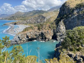 Scenic view of sea and mountains against sky