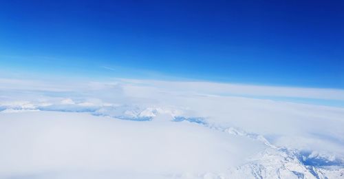 Scenic view of snowcapped mountains against blue sky