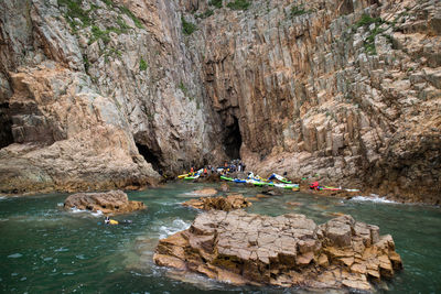 People on rock by water