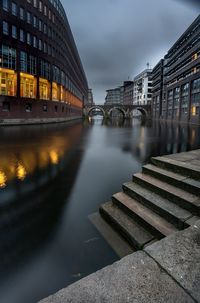 Bridge over river against sky at night