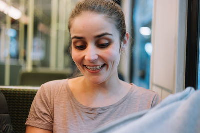 Smiling young woman sitting in restaurant at night
