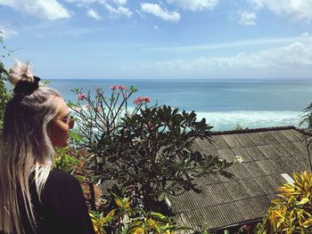 Beautiful woman looking at sea against sky