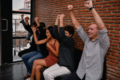 Smiling colleagues clenching fists in office