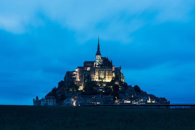 Illuminated building against sky at dusk