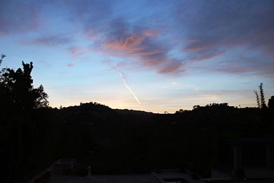 Silhouette trees against sky at sunset