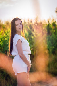 Young beautiful woman with brown hair in the corn field.