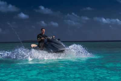 Man surfing on sea against sky