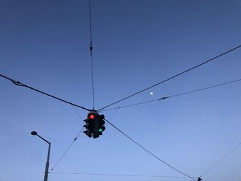 Low angle view of electricity pylon against clear sky