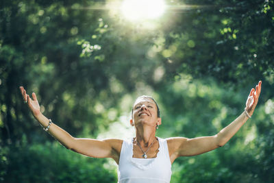 Mindfulness in nature. a positive middle-aged woman with open arms connecting with nature, feeling