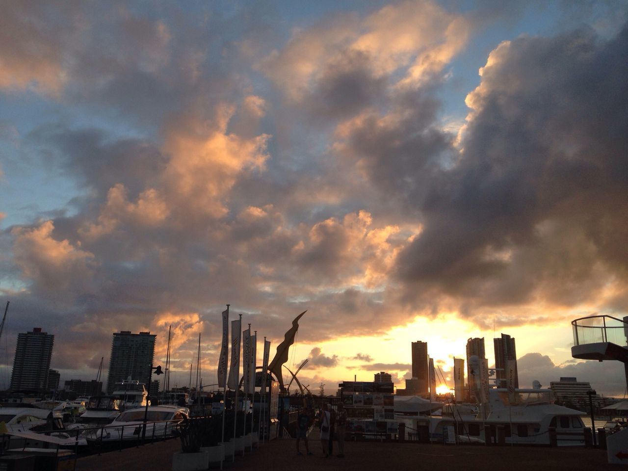 sunset, sky, cloud - sky, building exterior, architecture, built structure, cloudy, city, silhouette, dramatic sky, cloud, mode of transport, weather, orange color, transportation, overcast, outdoors, development, crane - construction machinery, building