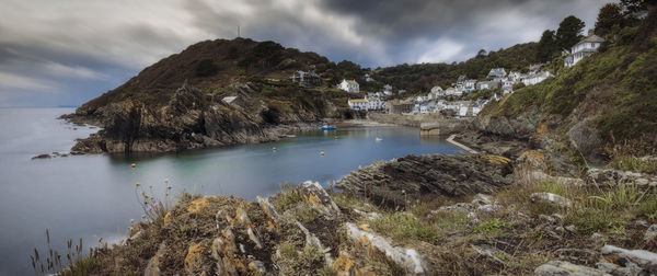 Polperro, cornwall. a wide-angle shot featuring headland and bay. long-exposure.