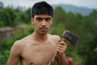 Portrait of young man holding axe