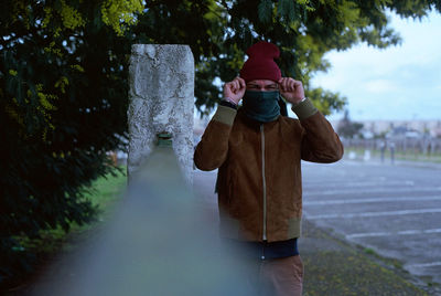 Full length of young woman photographing through mobile phone