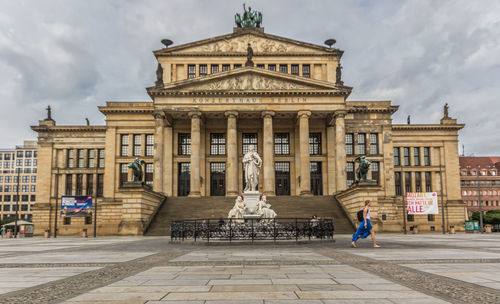 Facade of historic building against cloudy sky