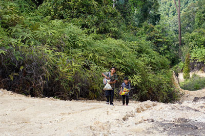 Father and son standing in forest