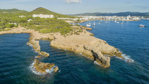 High angle view of sea by mountain against sky