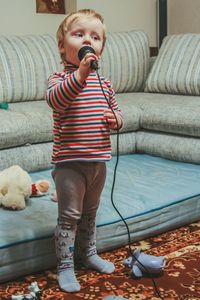 Full length of cute baby girl on sofa at home