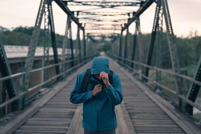 Man photographing on footbridge