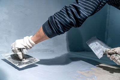 Cropped hand of man cutting metal