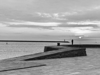 Promenade by sea against sky