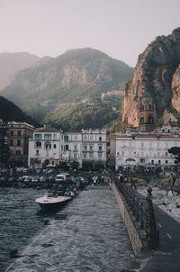 Boats on sea by buildings in city against clear sky