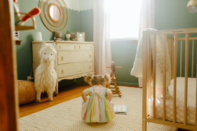 Toddler girl reading a book in her room