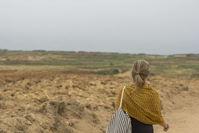 Rear view of woman standing on field