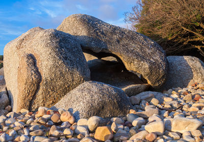 Stones on rocks at beach against sky