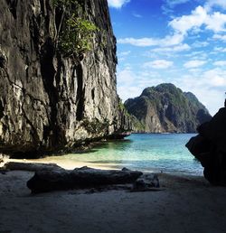 Rock formations by sea against sky