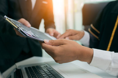 Midsection of man holding mobile phone