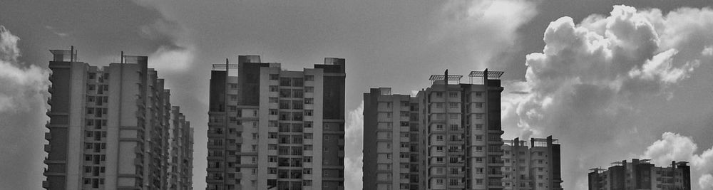 Modern buildings against cloudy sky