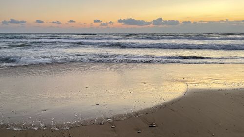 Scenic view of beach against sky during sunset