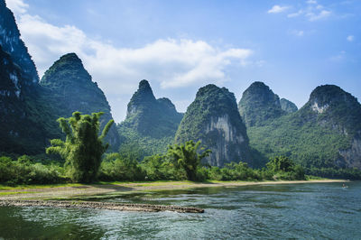 Scenic view of river and mountains against sky