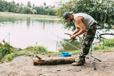 A young fisherman catches fish on a lake or river, prepares tackle and bait. hobbies, weekends